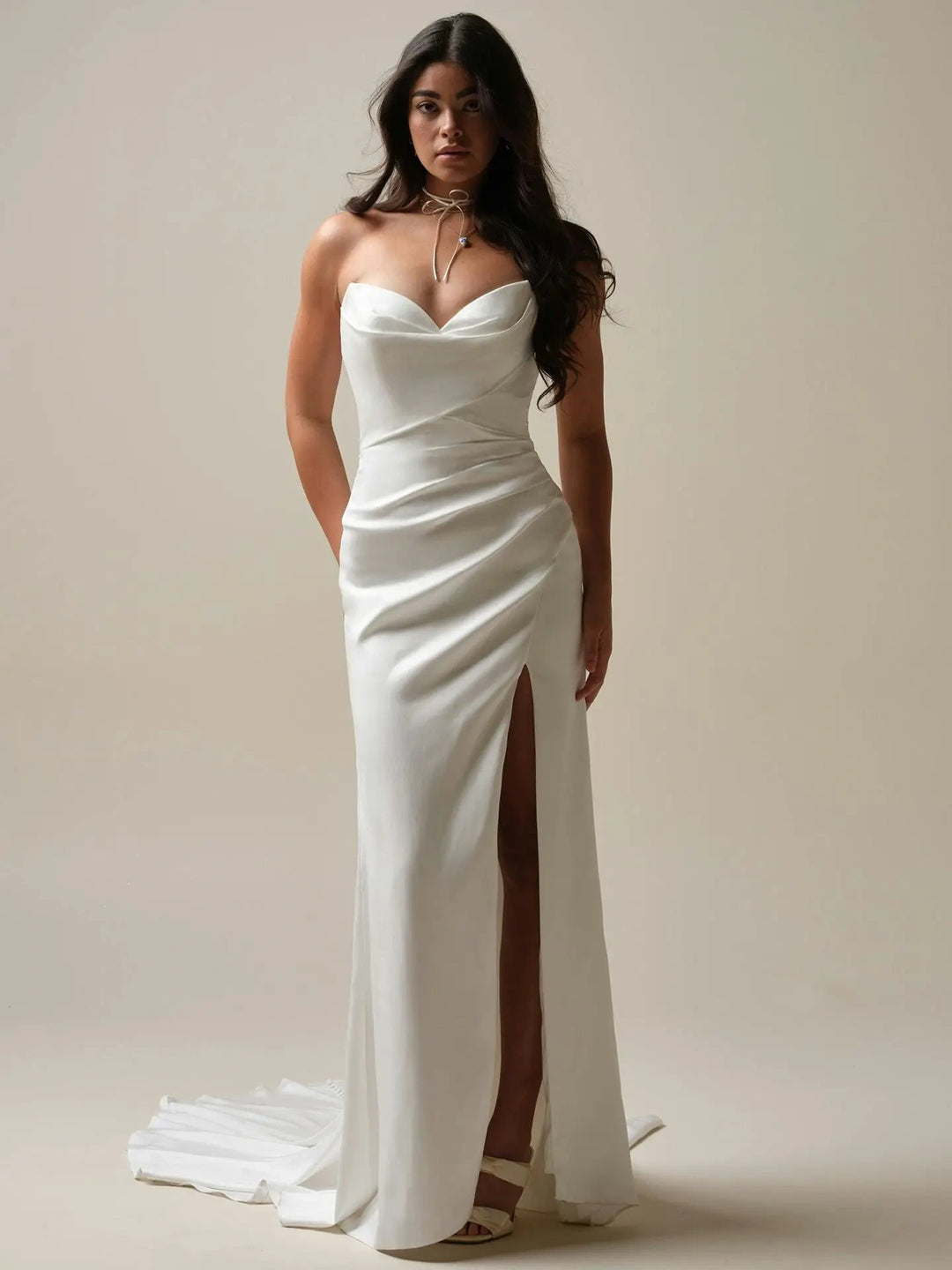 full front of maggie sottero camille ivory satin fitted wedding dress featuring a strapless v neckline, slit in the skirt, and showing without the matching overskirt