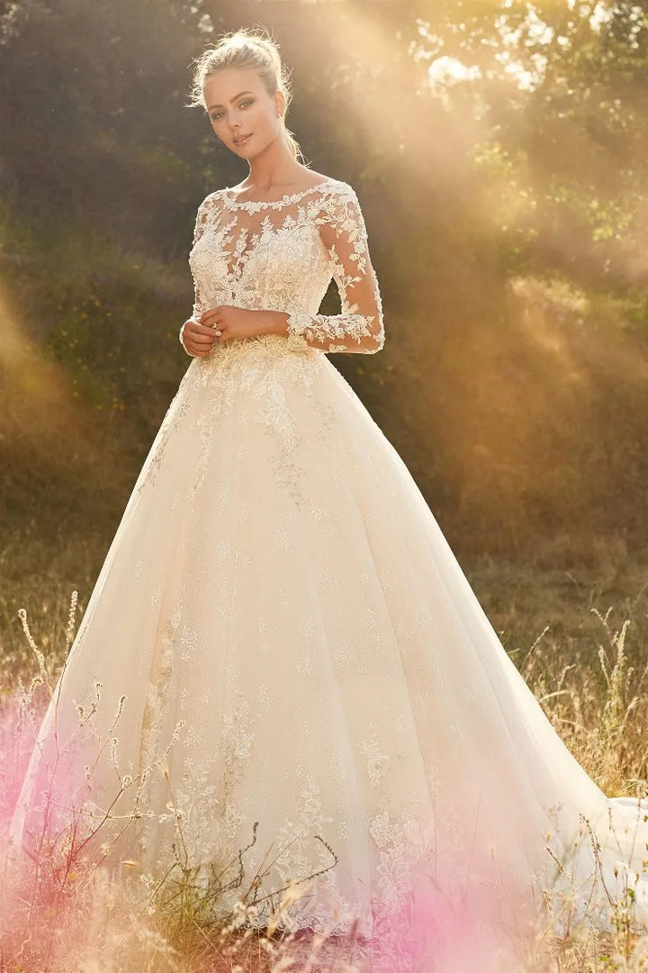 Woman in a white wedding dress standing in a field with sunlight filtering through.