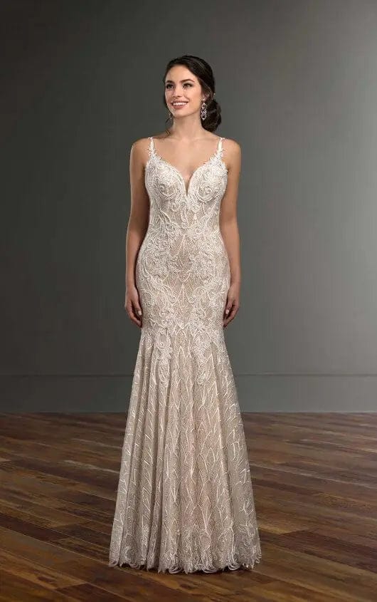 Woman wearing a lace evening gown against a gray background