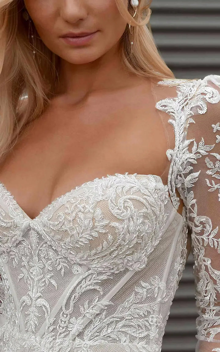 Close-up of a person wearing a white lace wedding dress with a blurred background