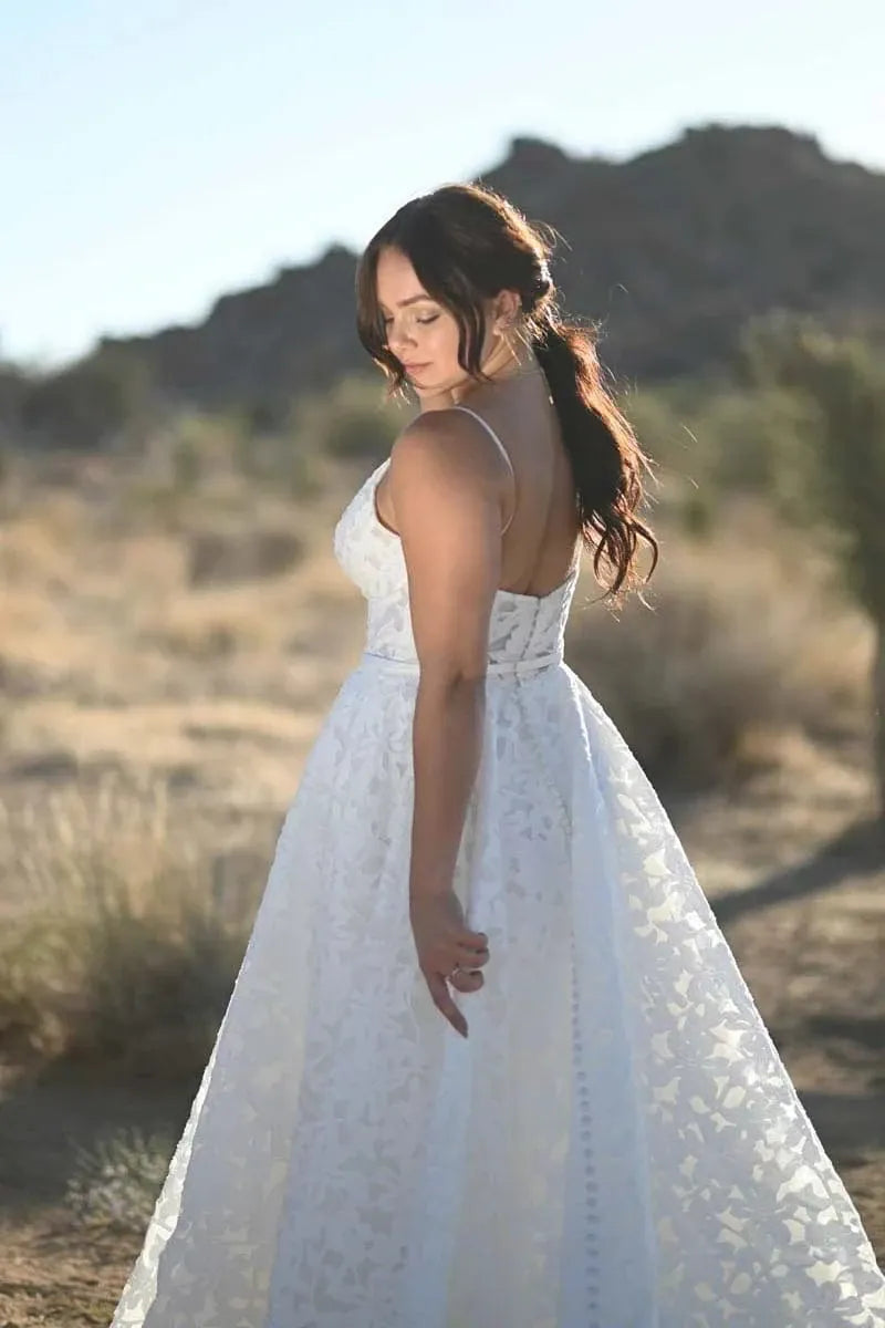 Woman in a white dress standing in a desert landscape