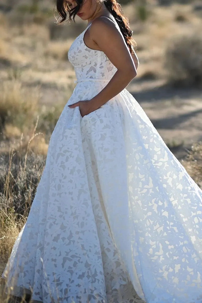 Woman in a white lace dress standing in a desert landscape