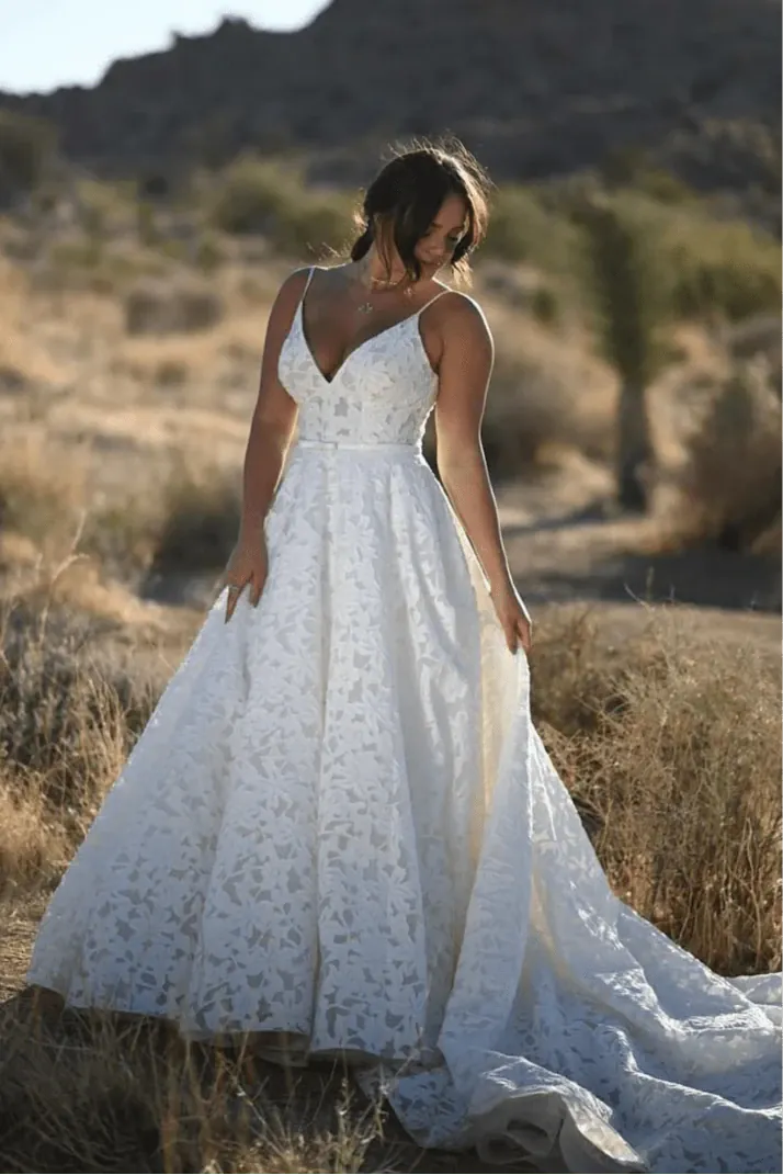 Woman in a white lace dress standing in a desert landscape