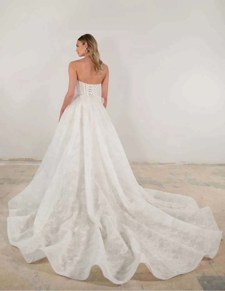 Woman wearing a white wedding dress with a plain background