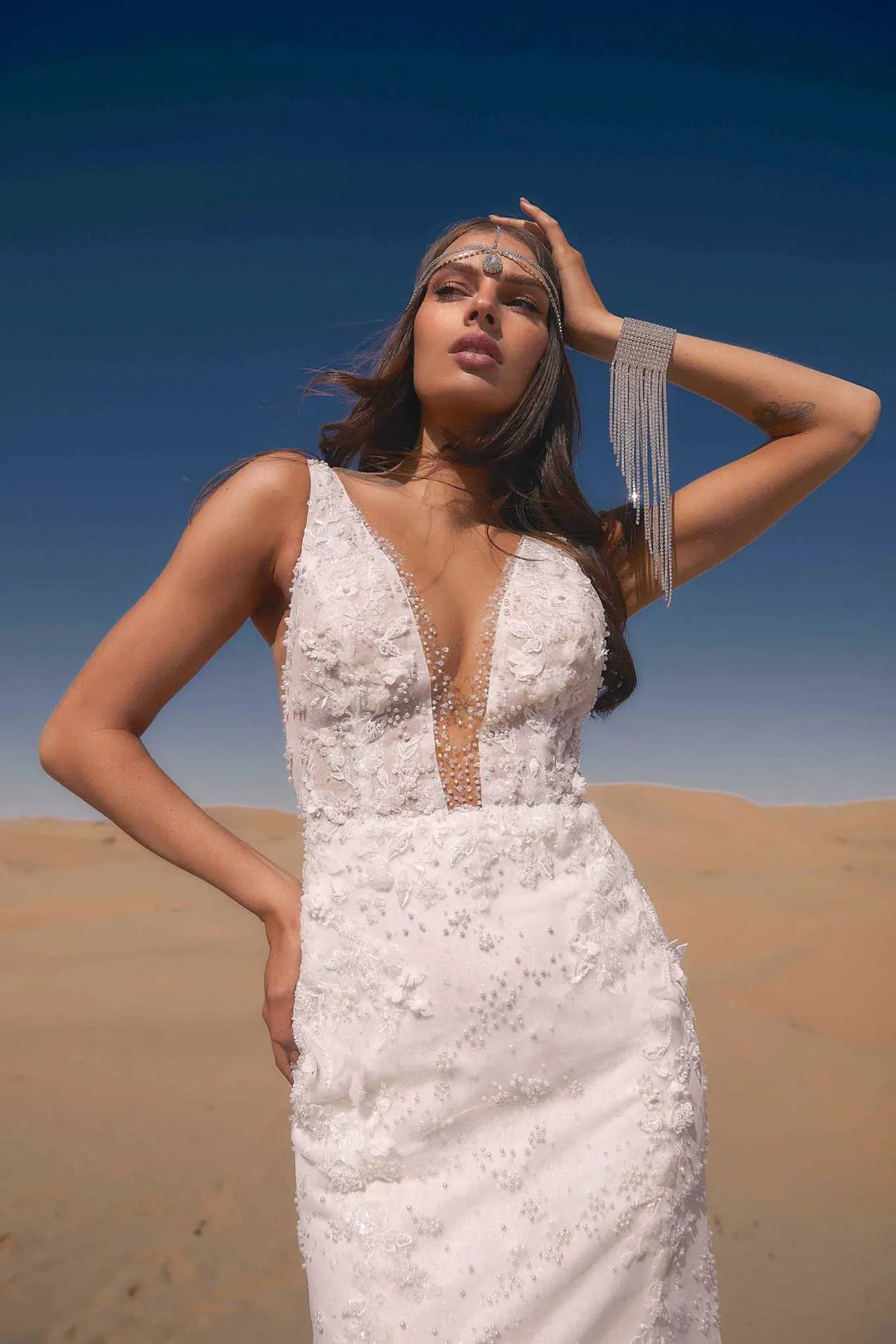 Woman in a white dress standing in a desert landscape
