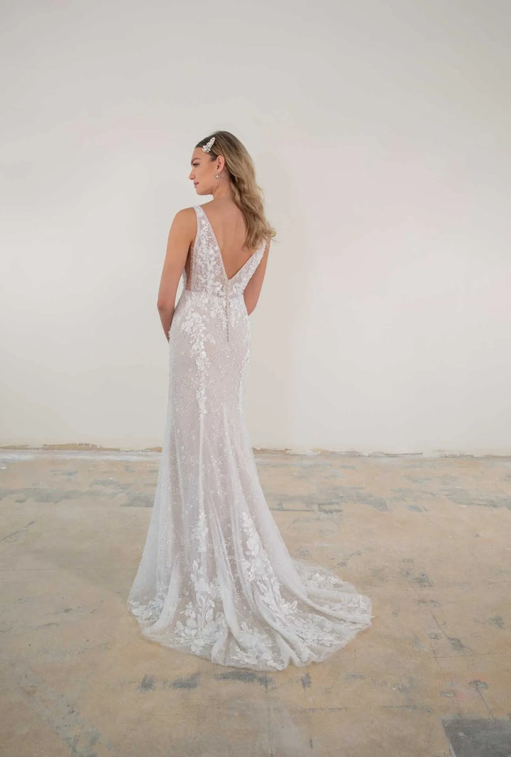 Woman wearing a lace wedding dress with a plain background