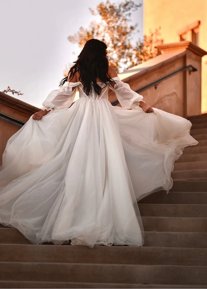 Woman in a white dress standing on steps with a blurred background