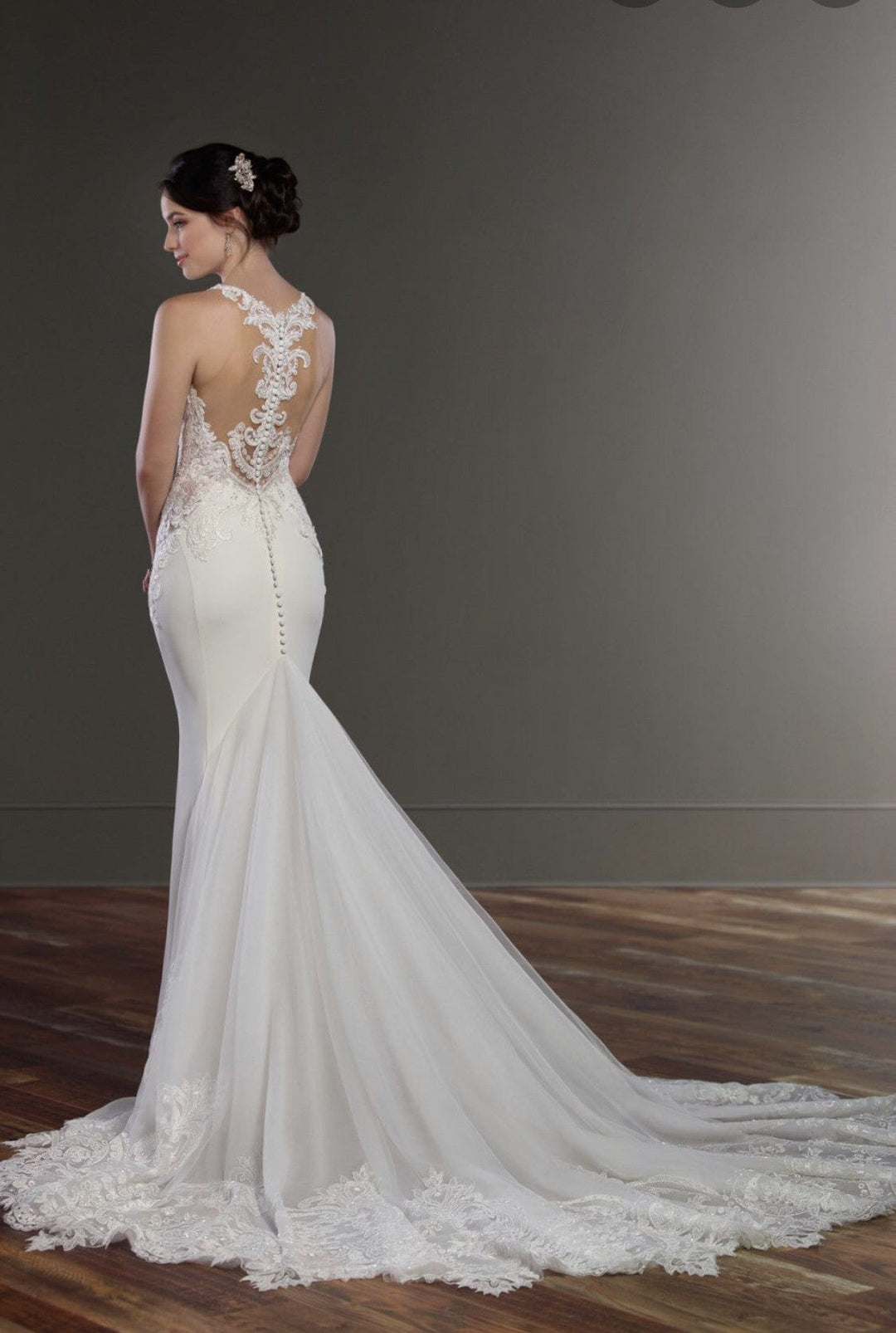 White wedding dress with intricate lace details on a plain background