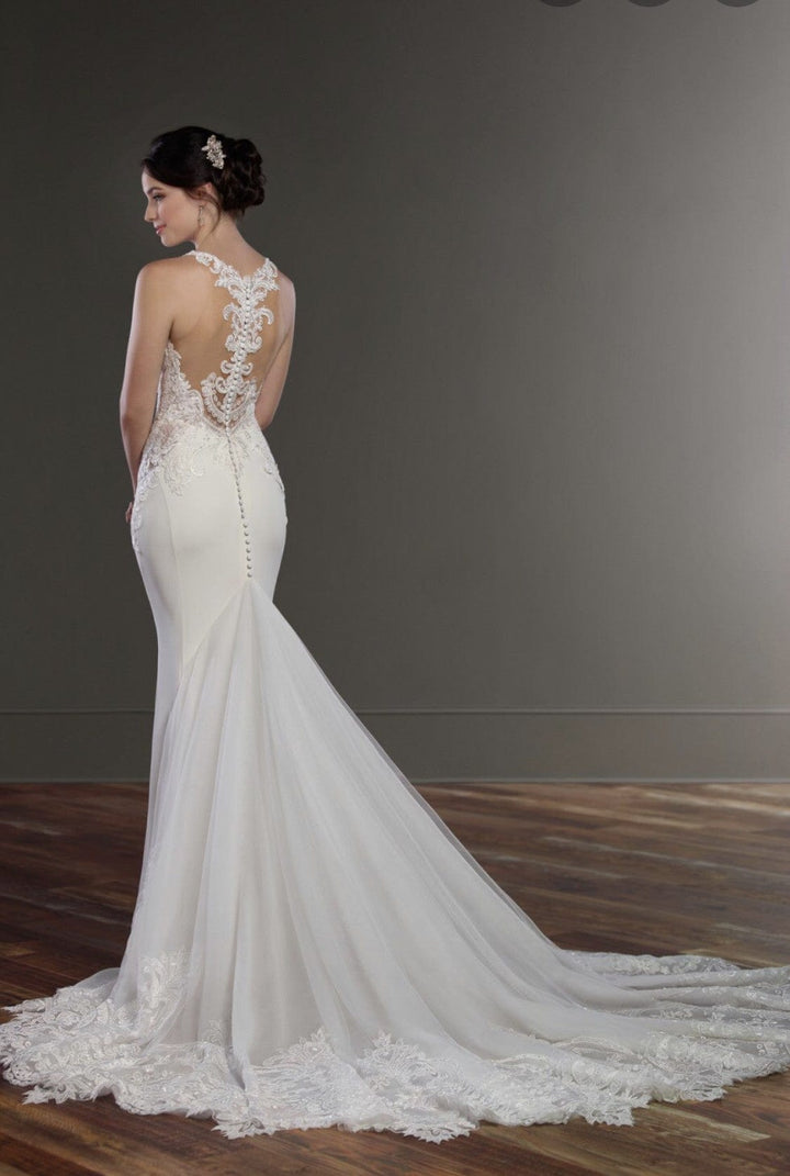White wedding dress with intricate lace details on a plain background