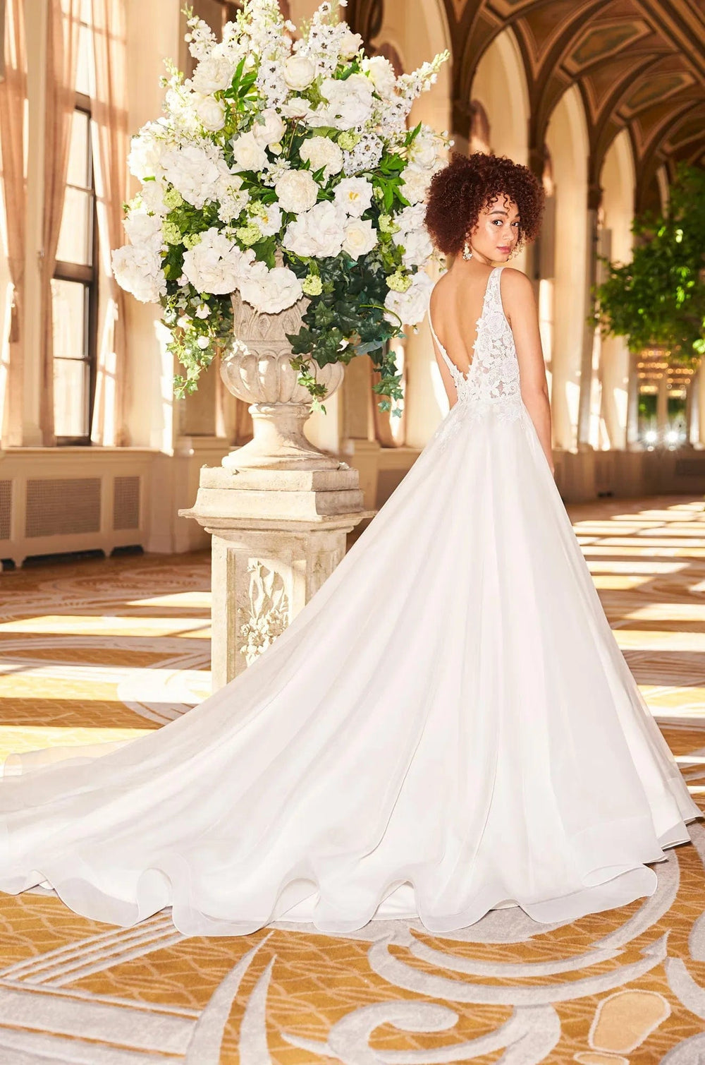 back of mikaella 2356 ivory tulle ball gown wedding dress with an open v back and a chapel length train