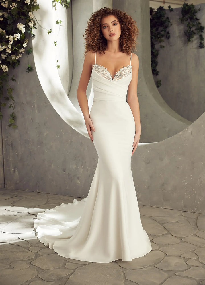 Woman in a white wedding dress with a long train in a decorated indoor setting