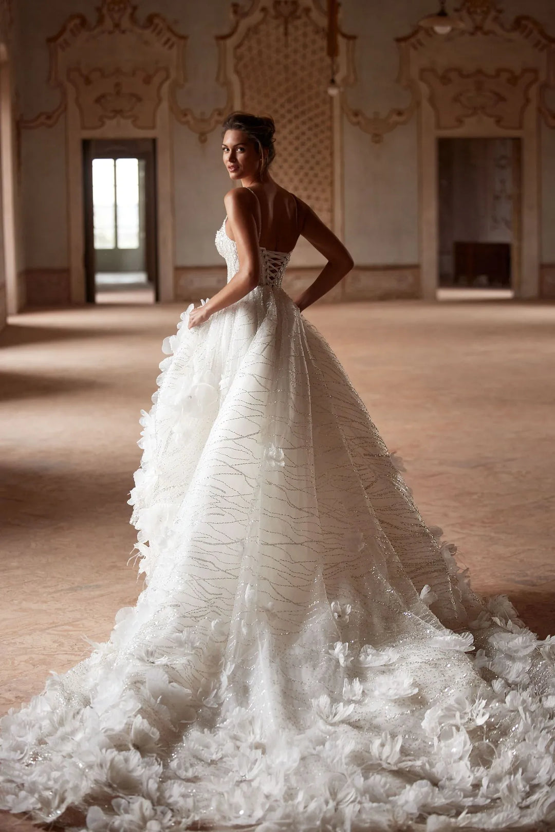 full back of milla nova sparkle ivory tulle ball gown with dimensional floral details, a strapless bodice, and a long train
