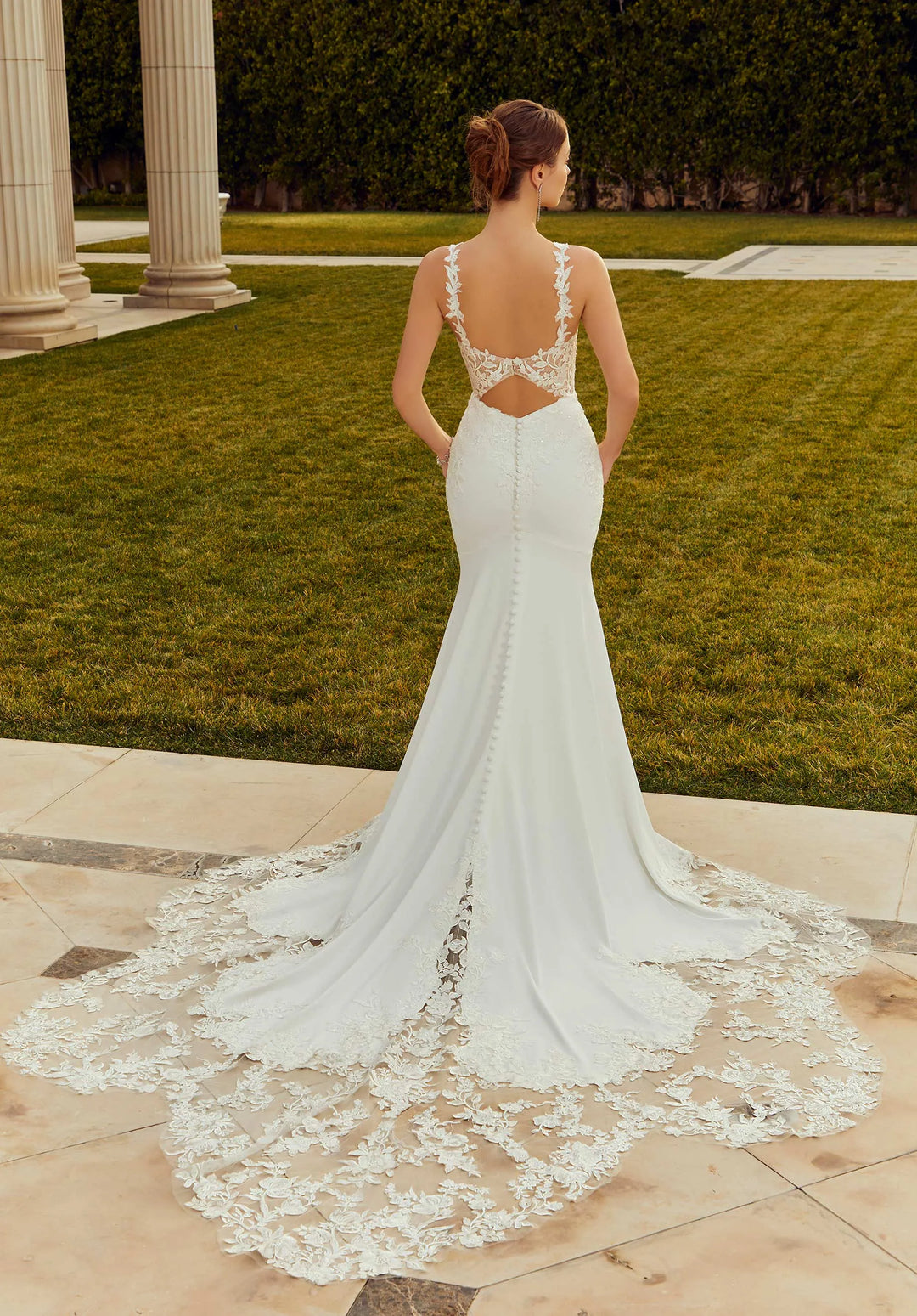 full back of morilee raquel ivory crepe fitted wedding dress featuring a keyhole back, lace appliques, and shaped long lace train