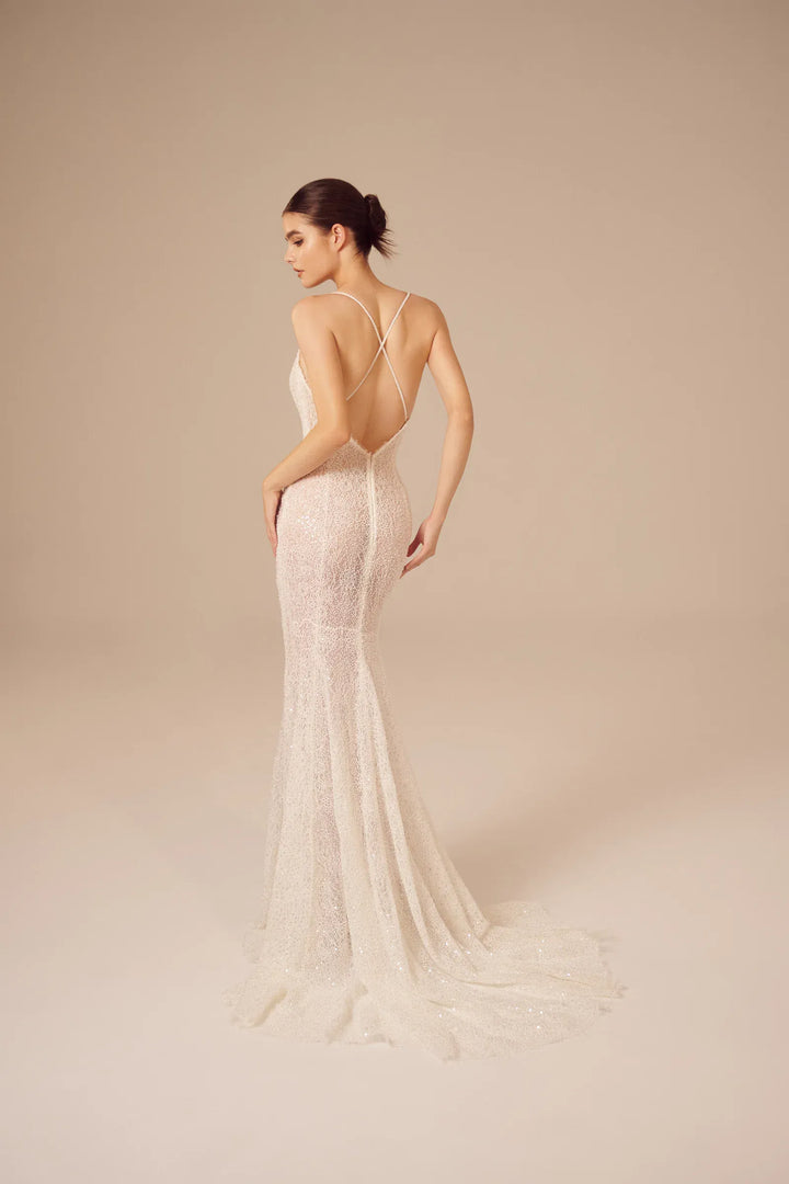 full back of nicole and felicia nf026 ivory lace fitted wedding dress featuring an open back with criss crossed straps and a short train
