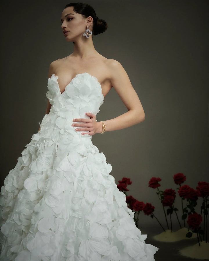 close up of nicole and felicia nf114 ivory organza ball gown showing the sweetheart neckline and floral petals throughout