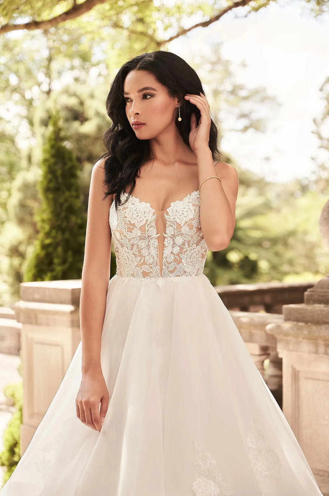 close up of paloma blanca 4930 ivory organza ball gown wedding showing the lace bodice with a deep neckline