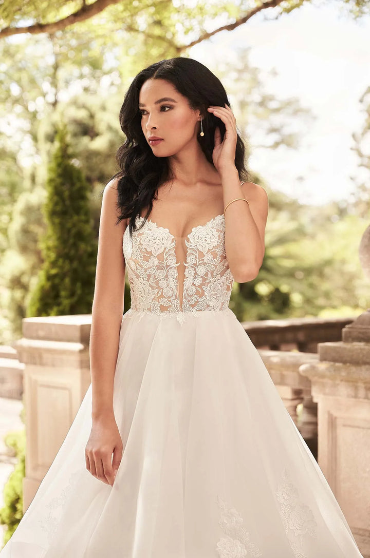 close up of paloma blanca 4930 ivory organza ball gown wedding showing the lace bodice with a deep neckline