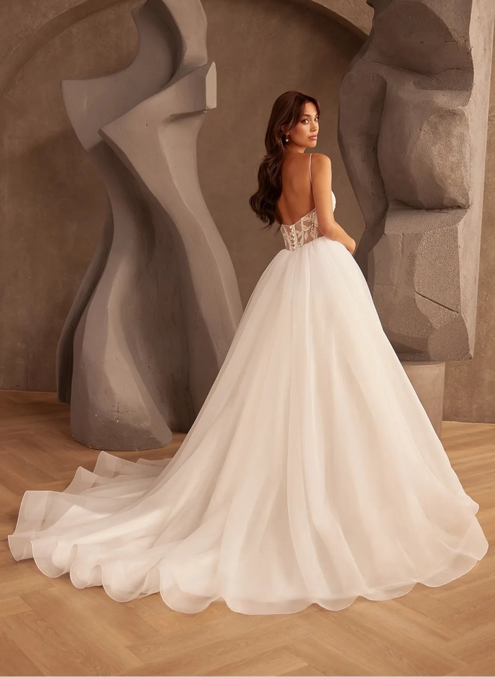 full back of paloma blanca p5126 ivory tulle ball gown wedding dress featuring a basque waist, lace bodice, and long frothy train