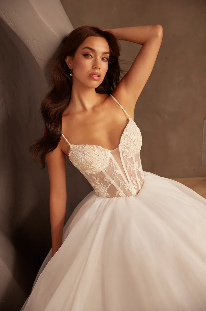 close up of paloma blanca p5126 ivory tulle ball gown wedding dress showing the lace bodice and basque waist