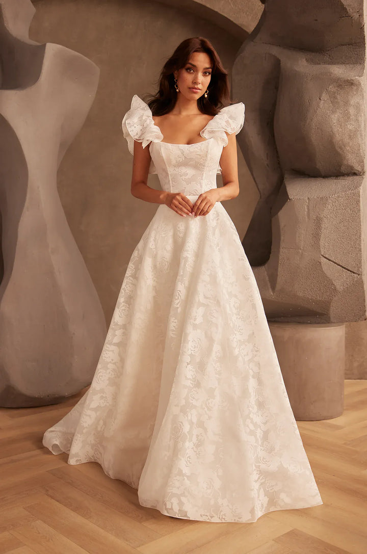 front of paloma blanca p5137 ivory burnout organza a-line wedding dress with a scoop neckline, shown with the matching ruffle straps