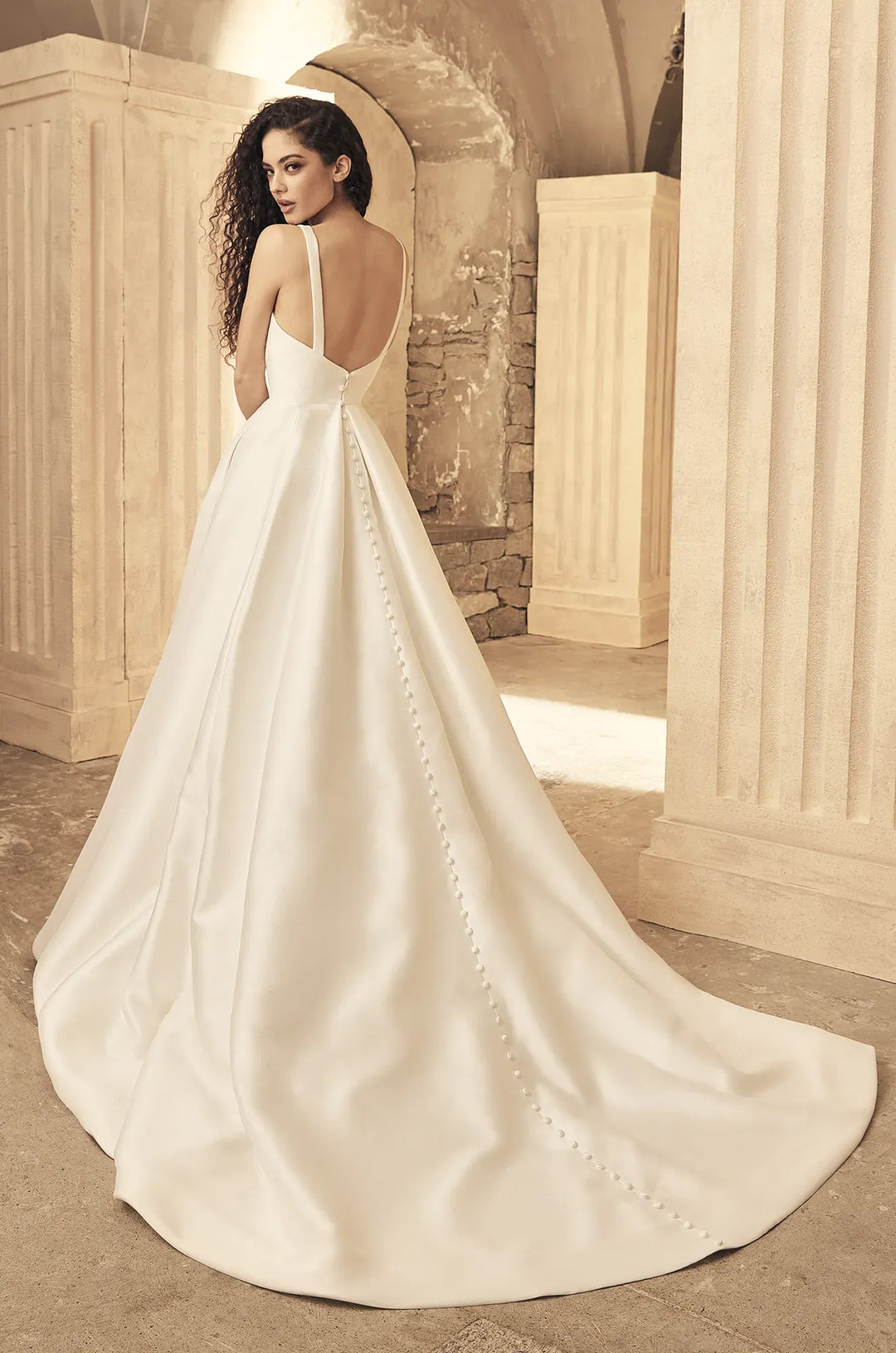 full back of paloma blanca p5150 ivory mikado a-line wedding dress with buttons down the back and a chapel length train