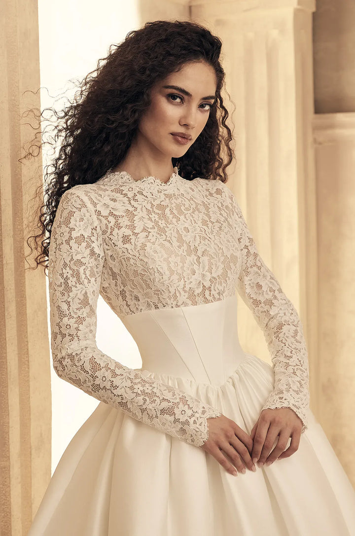 close up of paloma blanca p5154 ivory mikado ball gown wedding dress showing the lace bodice with a high neckline, and long sleeves