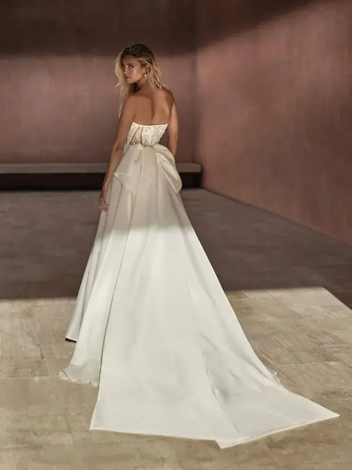 front of pronovias bayon ivory organza ball gown wedding dress with a strapless beaded bodice, shown with the matching bow train