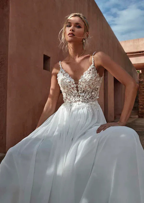 close up of pronovias corinzia ivory chiffon a-line wedding dress featuring a lace bodice with a v neckline