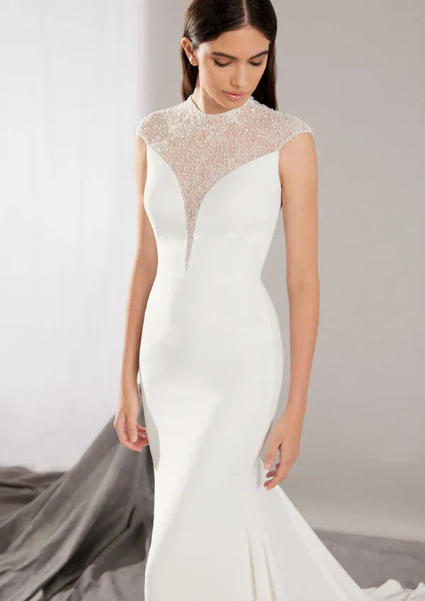 close up of pronovias honore ivory crepe fitted wedding dress with a beaded illusion neckline
