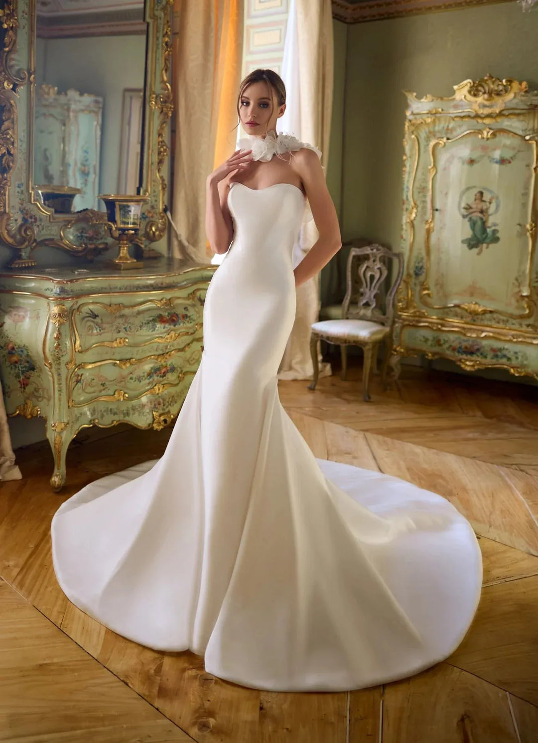 Woman in a white wedding dress standing in an ornate room with gold accents.