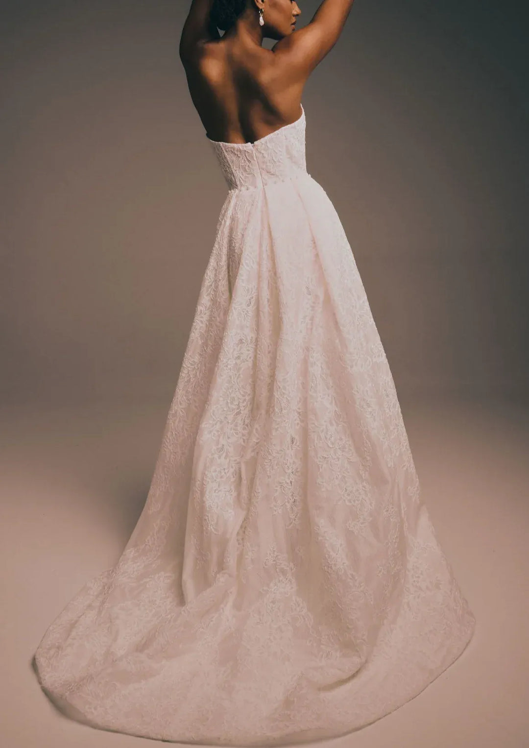 full back of renhue elara ivory lace fitted wedding dress with a strapless bodice and matching overskirt