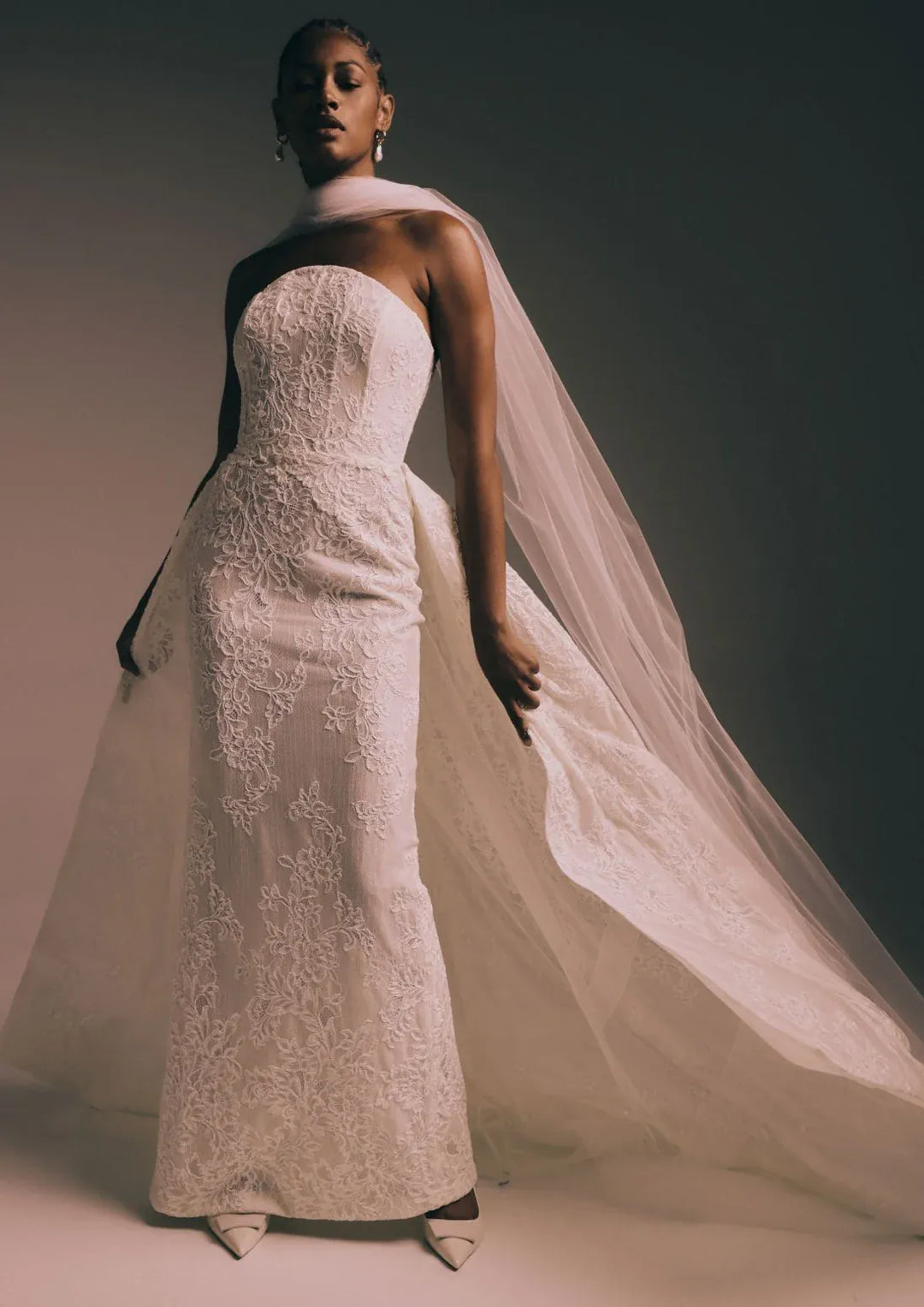 full front of renhue elara ivory lace fitted wedding dress with a strapless bodice and matching overskirt