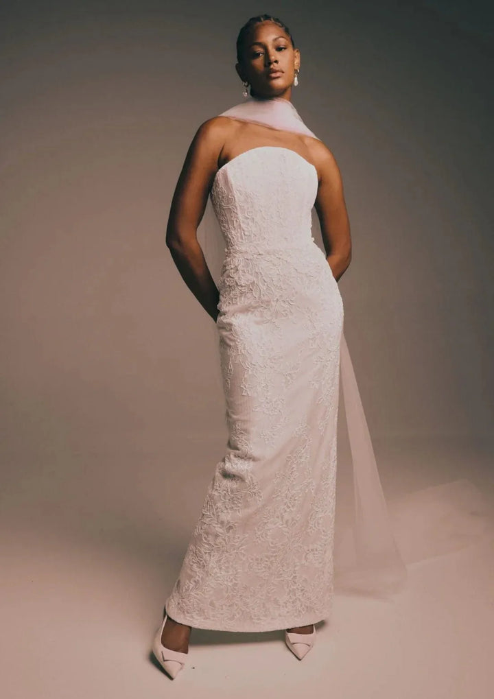 full front of renhue elara ivory lace fitted wedding dress with a strapless bodice, shown without the matching overskirt