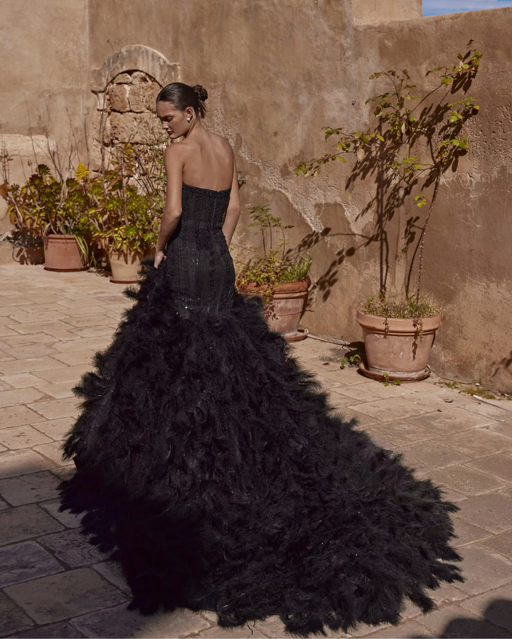 back of ricca sposa 25-013 black fit and flare wedding dress with a beaded strapless bodice and feathered skirt that extends into a long train