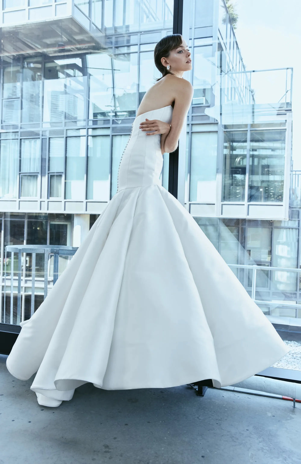 back of rivini clair ivory silk fit and flare wedding dress with buttons down the back and chapel length train