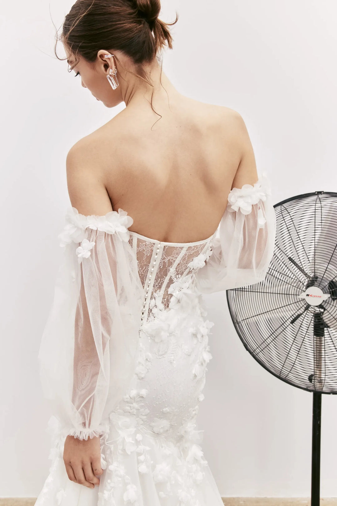 close up of rivini jax ivory lace fit and flare wedding dress showing the sheer back and floral details