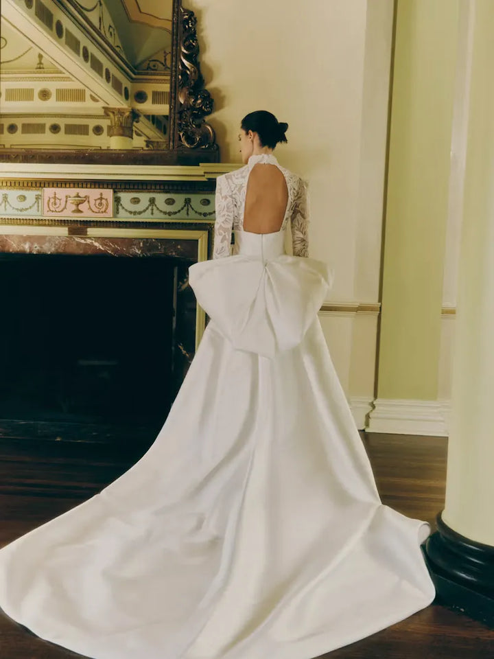 full back of rivini kit ivory satin fitted wedding dress with a lace bodice and matching overskirt with a bow