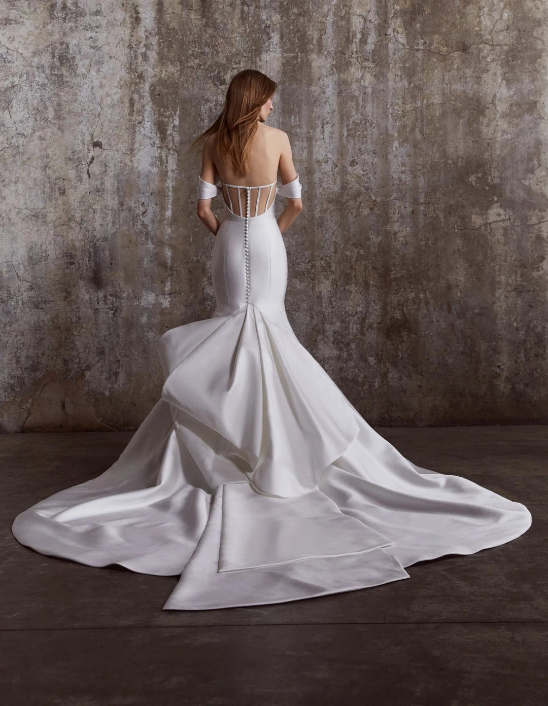 back of rivini phoebe ivory satin fit and flare wedding dress showing the full back with the sheer back and bow train