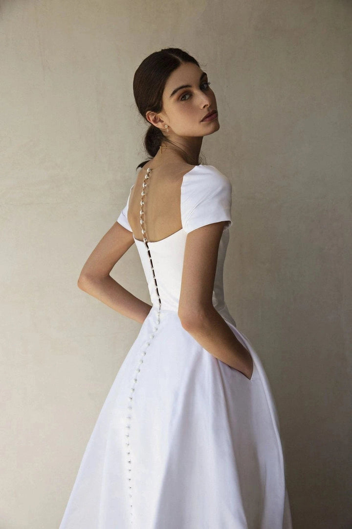 Full back of Sarah Seven Grace white crepe A-line gown with sheer back and button closure