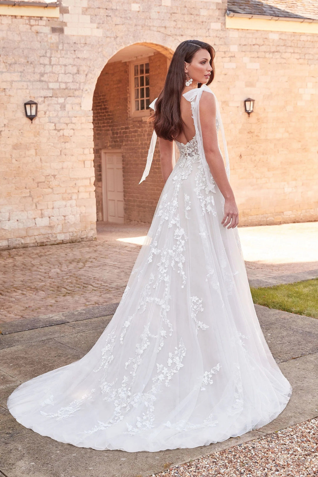 full back of sincerity bridal 44346 nude tulle a-line wedding dress showing the scattered lace appliques and chapel length train