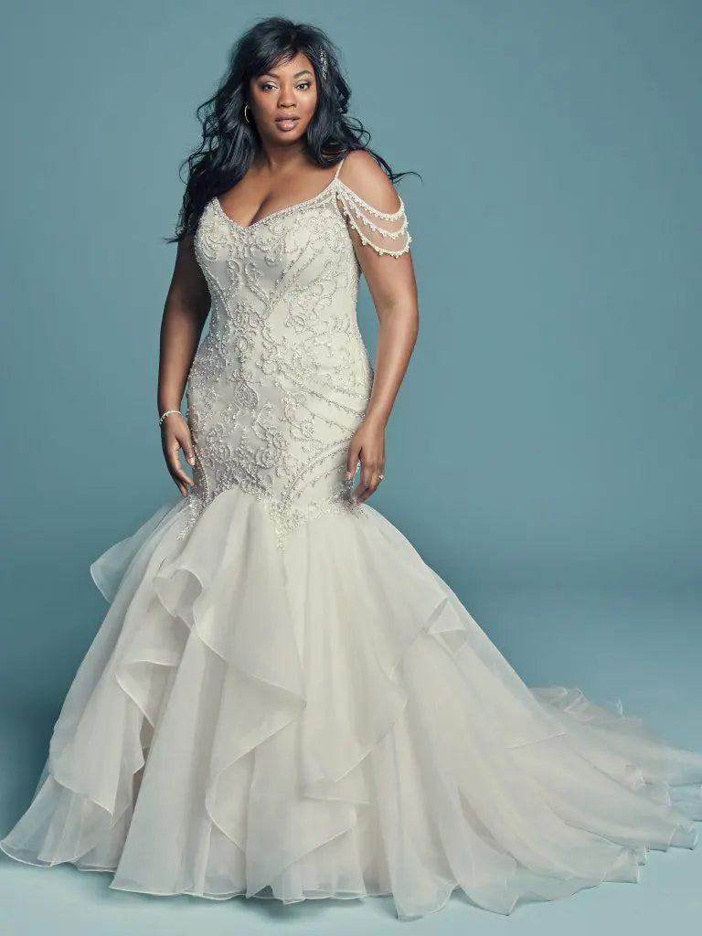 Woman wearing a white wedding dress with lace details on a blue background