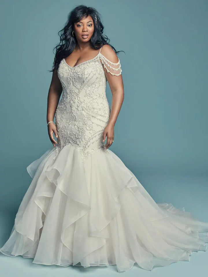 Woman wearing a white wedding dress with lace details on a blue background