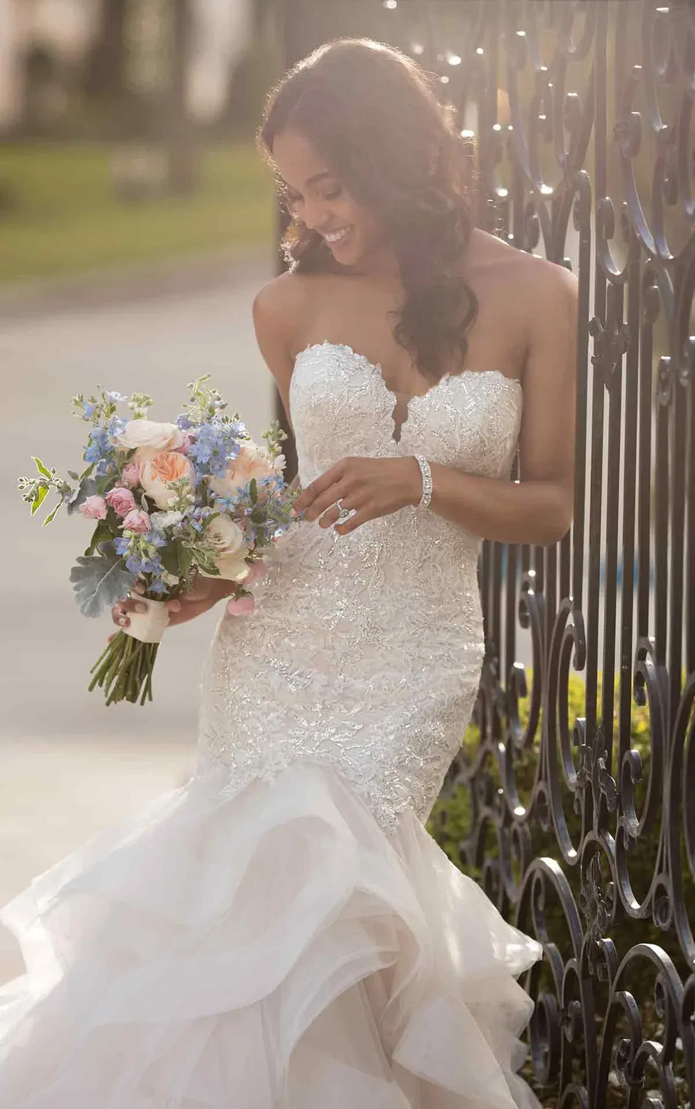 close up of stella york 6750 blush tulle fit and flare wedding dress with a tiered ruffle skirt and beading on the bodice