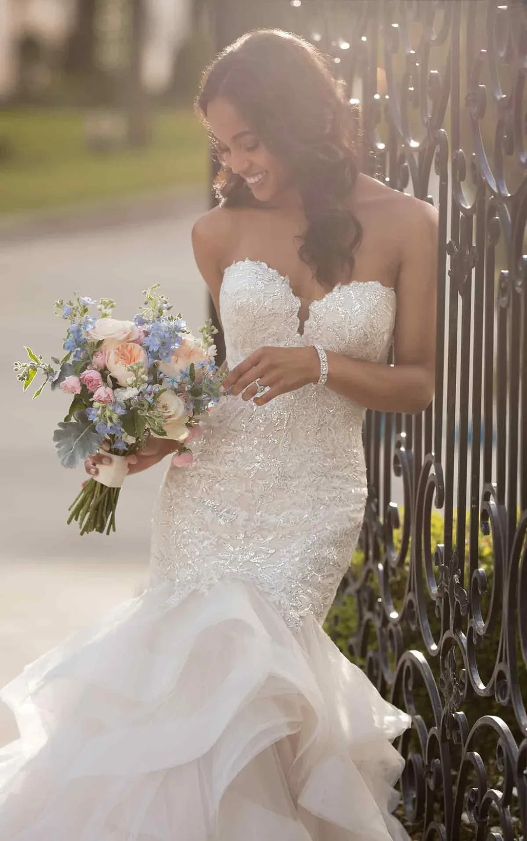 close up of stella york 6750 blush tulle fit and flare wedding dress with a tiered ruffle skirt and beading on the bodice