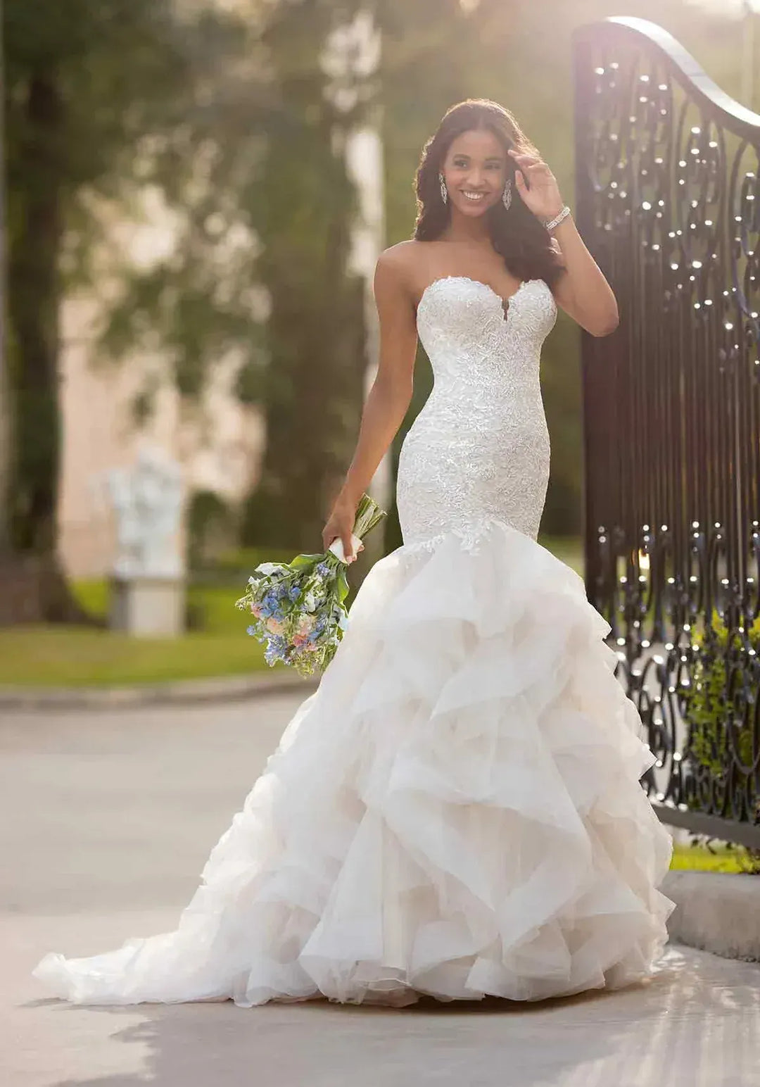 full front of stella york 6750 blush tulle fit and flare wedding dress with a tiered ruffle skirt and beading on the bodice