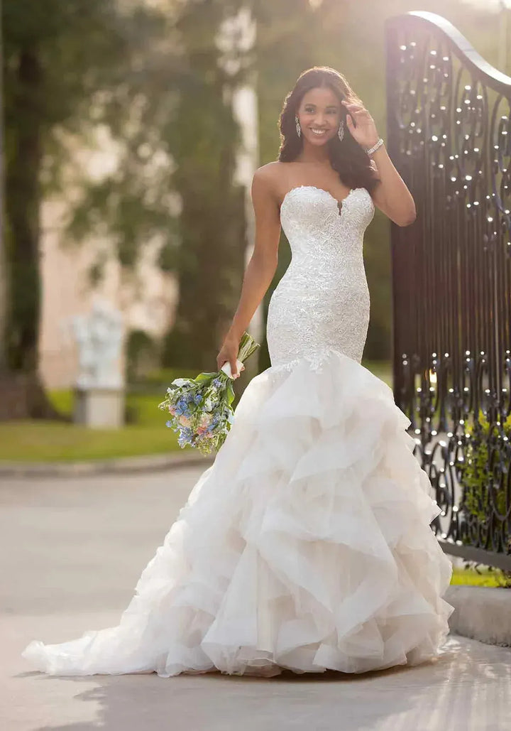 full front of stella york 6750 blush tulle fit and flare wedding dress with a tiered ruffle skirt and beading on the bodice