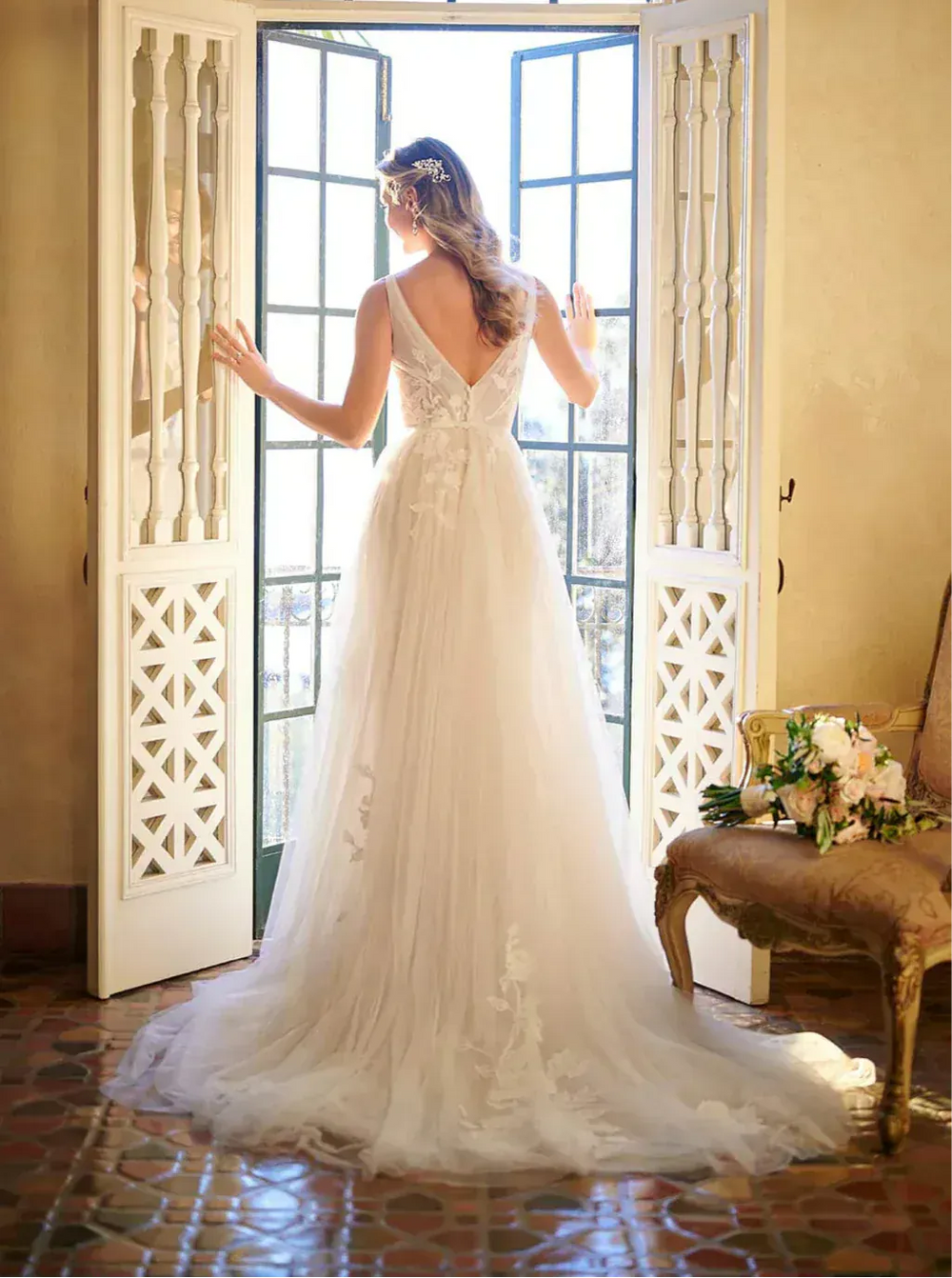 full back of stella york 7126 moscato tulle a-line wedding dress featuring a v back and scattered floral appliques, with a short train