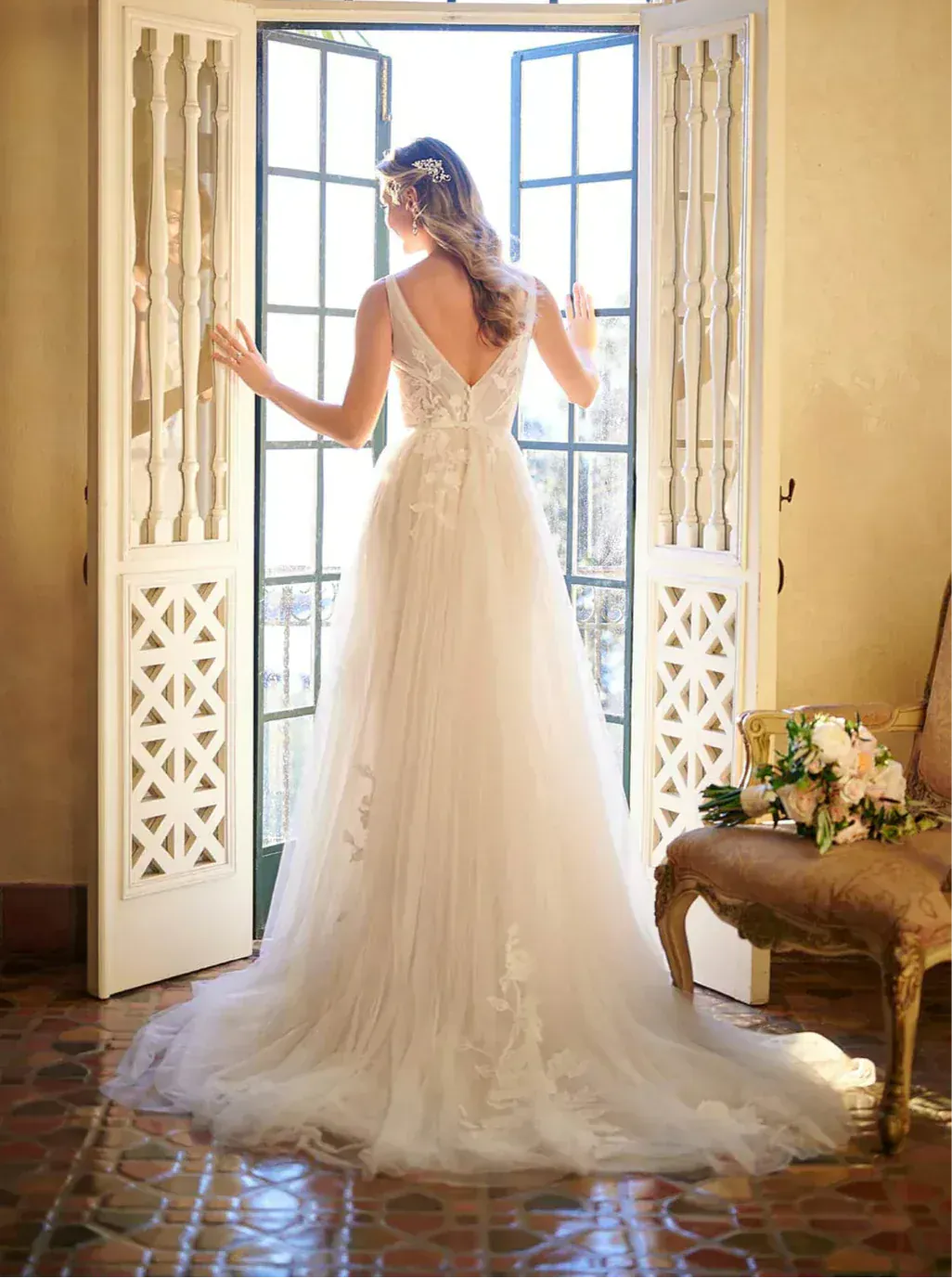 full back of stella york 7126 moscato tulle a-line wedding dress featuring a v back and scattered floral appliques, with a short train