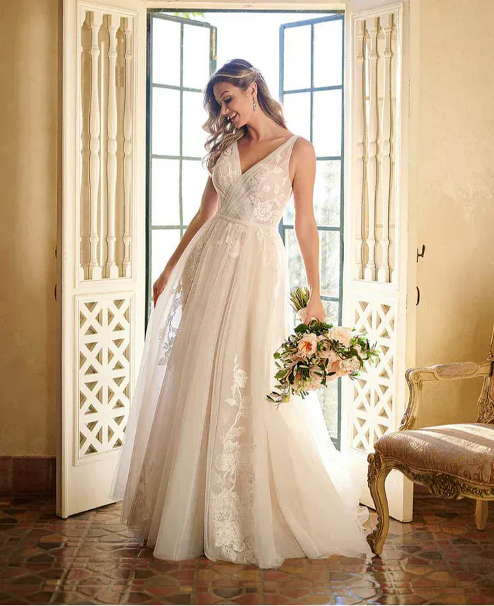 full front of stella york 7126 moscato tulle a-line wedding dress featuring a v neckline and scattered floral appliques