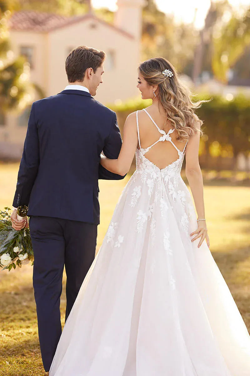 Man and woman in wedding attire walking together outdoors.